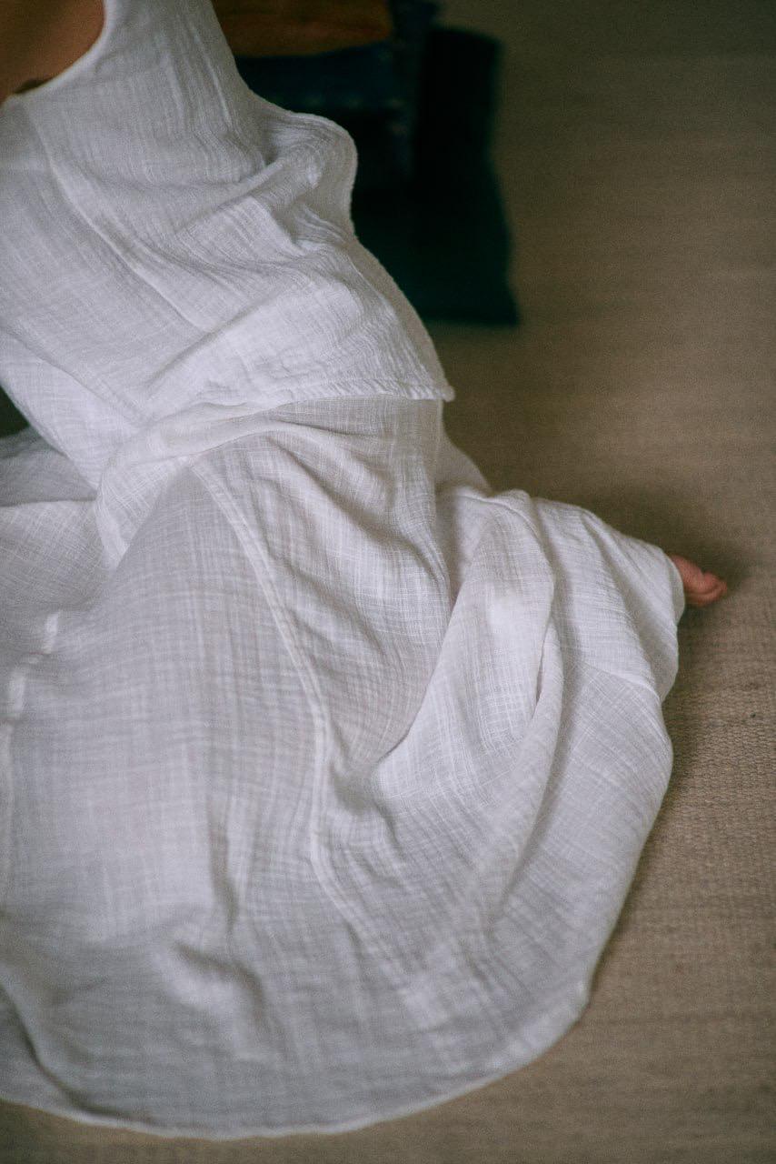 A person wearing a White midi skirt with a flowing A silhouette, sitting on the floor - view from above.