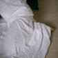 A person wearing a White midi skirt with a flowing A silhouette, sitting on the floor - view from above.