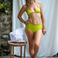 This image features the a woman wearing a KAVERI Bikini, a beautifully designed swimwear piece that exudes elegance and spirit. The bikini comes in a striking shade of lime green, reminiscent of vibrant tropical waters and lush earth tones.