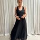 A woman wearing a Shivani black maxi linen dress in front of a white background.