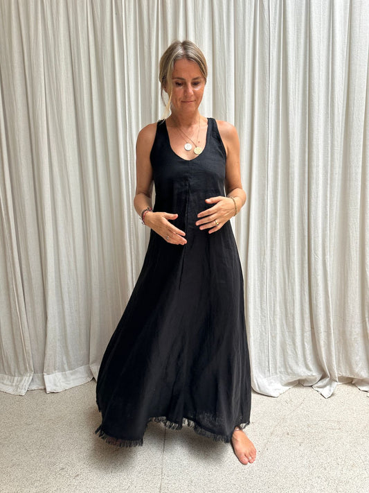 A woman wearing a Shivani black maxi linen dress in front of a white background.