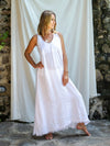 A woman wearing a white maxi v-neck linen dress, posing in front of a white backdrop.