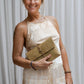 A woman wearing a beige silk romper with a halter neckline and wide-leg silhouette, tea-dyed for earthy tones.