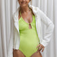A woman is wearing the Vipasha One-Piece Swimwear, a monokini in a striking shade of lime, with a white hoodie from Shivani.