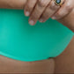 This image features the KAVERI Bikini detail (the bottom), a beautifully designed swimwear piece that exudes elegance and spirit. The bikini comes in a striking shade of lime green, reminiscent of vibrant tropical waters and lush earth tones.